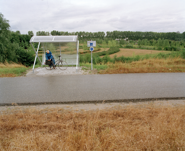 823905 Afbeelding van een constructie waaronder fietsers kunnen schuilen tegen de regen, langs een fietspad in de ...